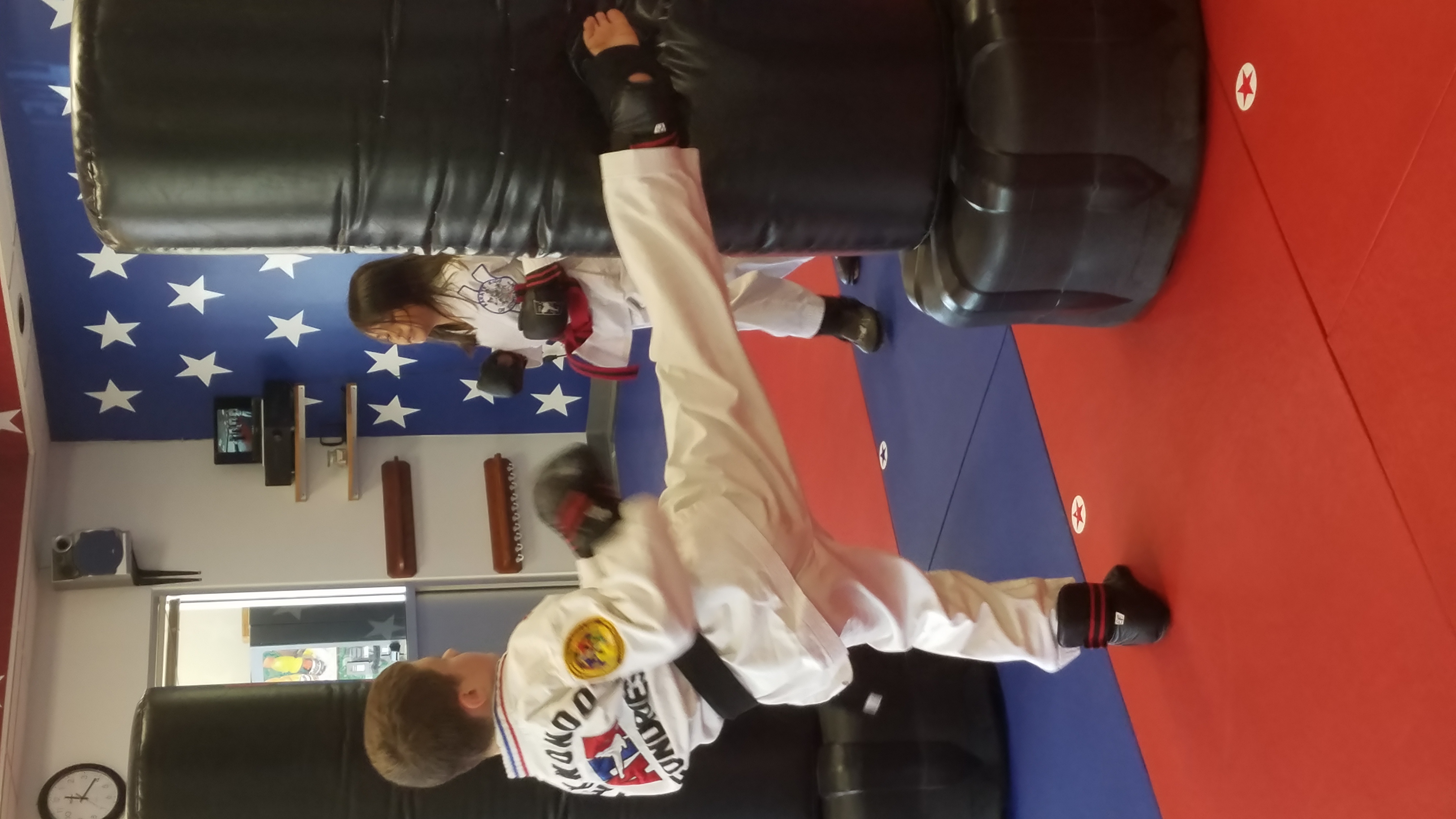 Karate Kids student practicing a kick on training shields